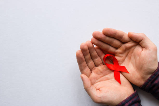 세계 에이즈의 날의 상징을 들고 있는 남자 - aids awareness ribbon 뉴스 사진 이미지