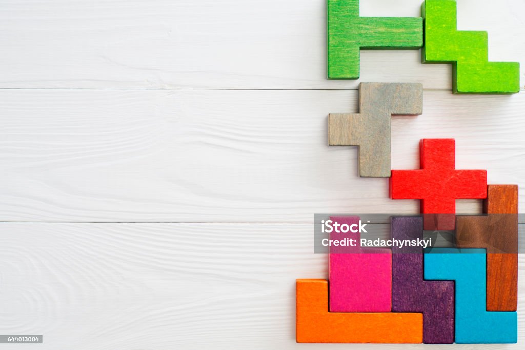 Concept of creative, logical thinking. Concept of creative, logical thinking.  Different colorful shapes wooden blocks on white wooden background, flat lay, copy space. Geometric shapes in different colors, top view. Abstract Background. Toy Block Stock Photo