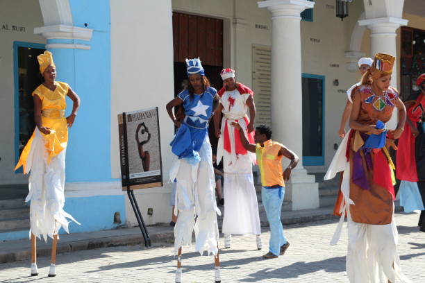 Havana, Cuba - December, 12, 2016: Photo taken in Havana Vieja, the old town. Entertainers on stilts in colourful clothing dancing to music.