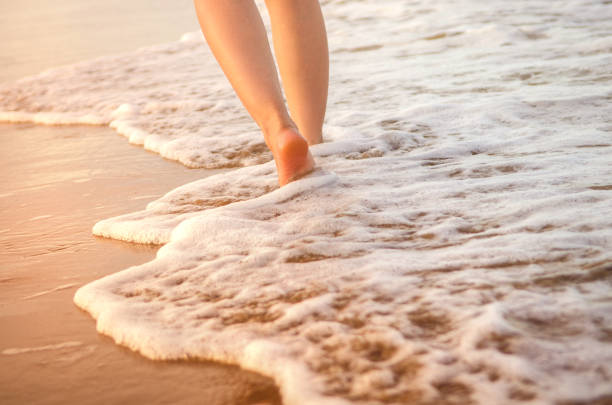 istock Woman walking on wet sandy beach 644037868