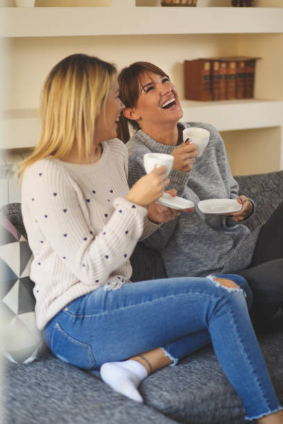 istock Two young cheerful female friends enjoying coffee and conversation 644041286