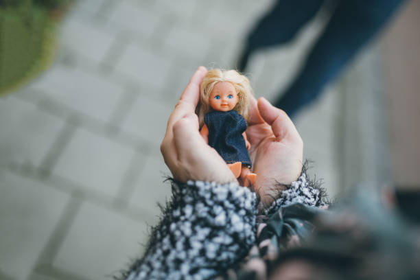 Woman holding little doll in hands
