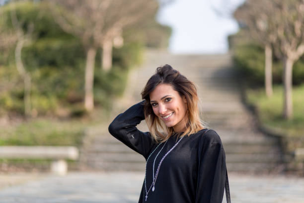 istock Beautiful young woman in a park 644051300