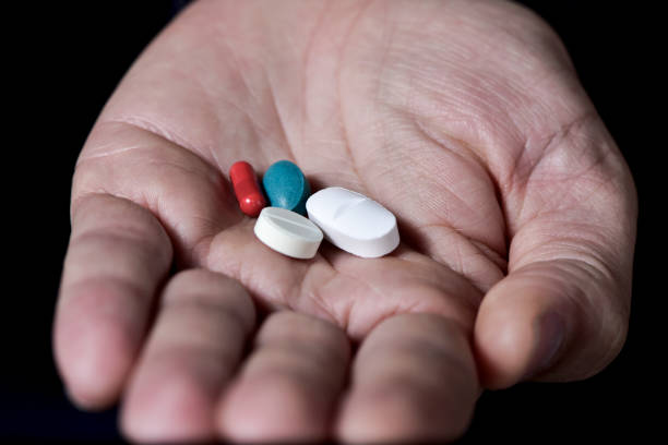 istock pills in the hand of a young man 644063542