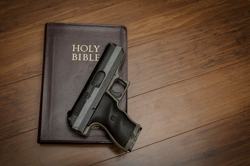 automatic pistol with a brown bible
