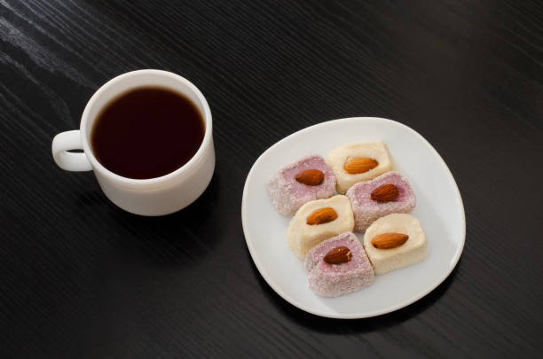 istock Coffee mug, saucer with Turkish Delight on a black table, top view 644066584