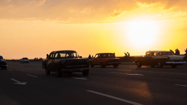 istock Classic cars driving on the Cuban malecon during sunset 644066754