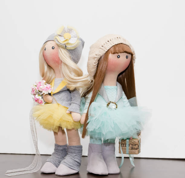 Two handmade rag dolls with natural hair - blonde and brown-haired, in knitted hats