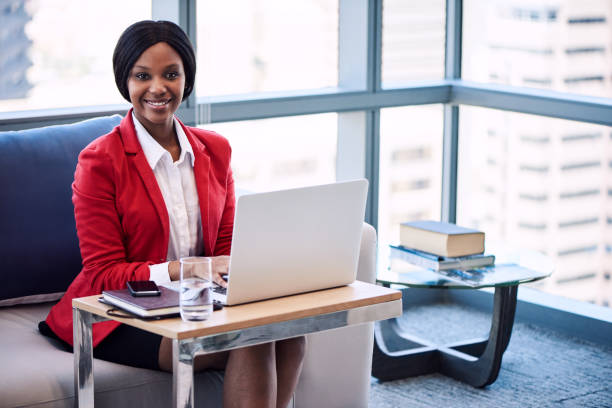istock Black businesswoman smiling at the camera while seated on sofa 644071198