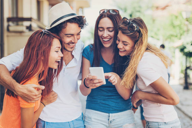 istock Four young people looking at smart phone and laughing 644080346