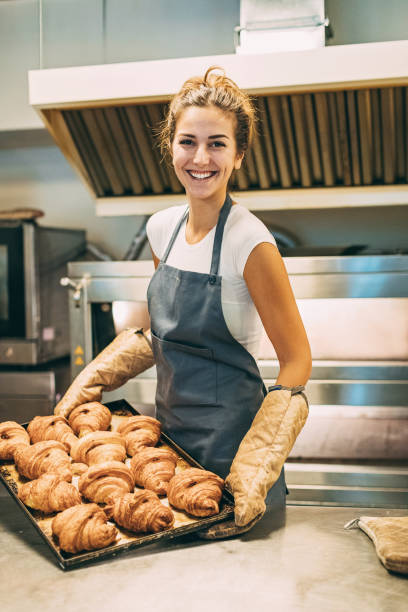 istock Cheerful baker with tray of fresh croissants 644080464