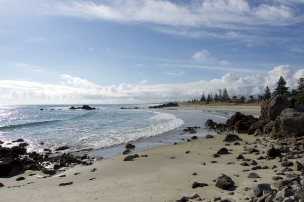 istock Black stones on a wide long beach 644083582
