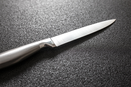 Kitchen knife on black table.