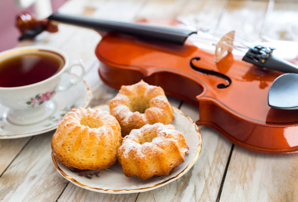 Coffee with cupcakes and violin on the wooden table stock photo