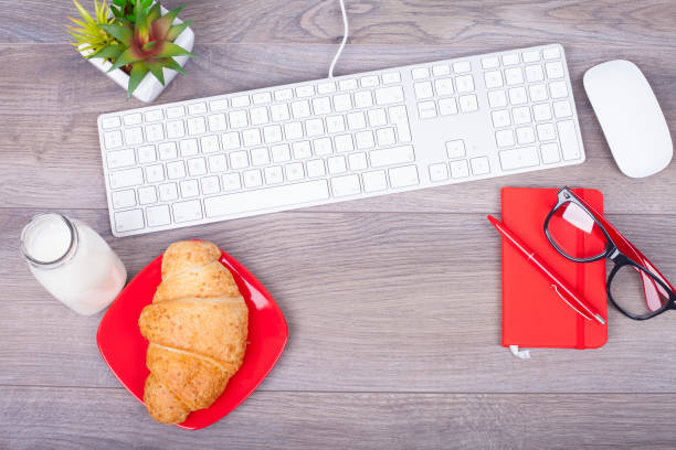 Working table with a keyboard Keyboard and breakfast on a wooden table from above apple keyboard stock pictures, royalty-free photos & images