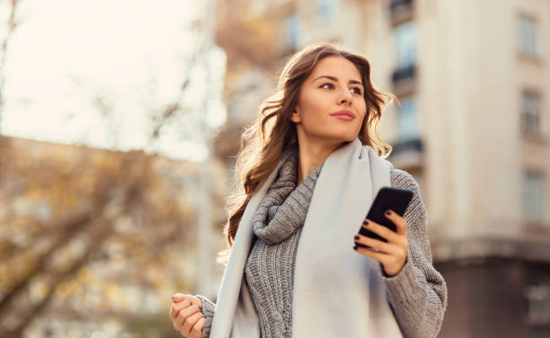 istock Young woman texting outdoors 644115668