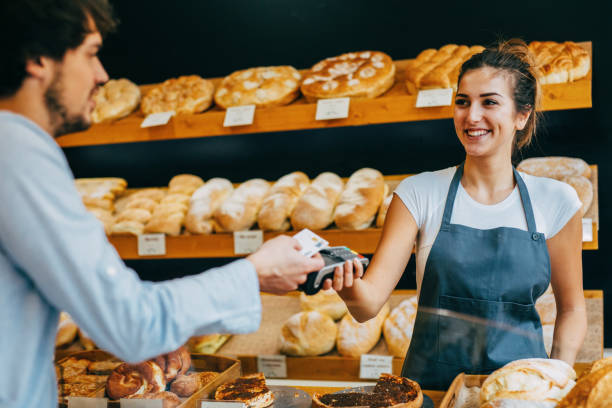 istock Young man making a contactless payment at a bakery 644115692