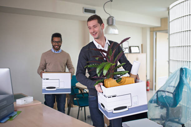 istock Businessmen carrying crates in new office 644119144