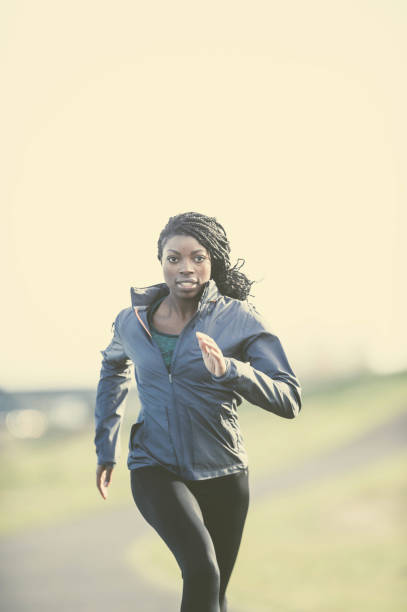 istock African American woman training and jogging by river 644132188