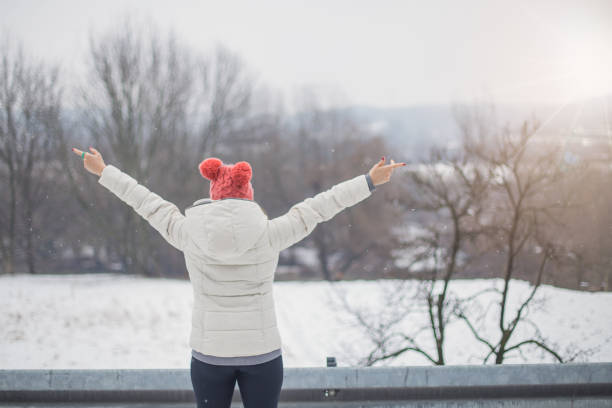 istock Female outside on snow with arms outstretched 644135344