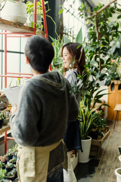 istock Two gardeners working in green shop. 644135574