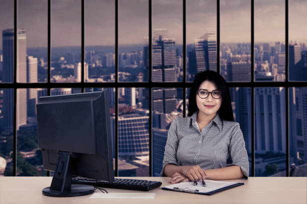istock Confident businesswoman with computer and paperwork 644182030