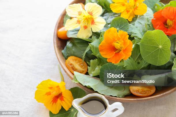 Fresh Green Salad With Edible Flowers Nasturtium In Wooden Serving Dish Stock Photo - Download Image Now