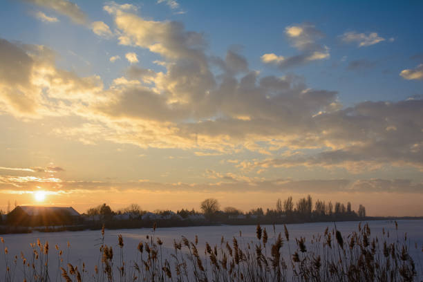 istock Sunset over the frozen Tisa river covered with snow 644190054