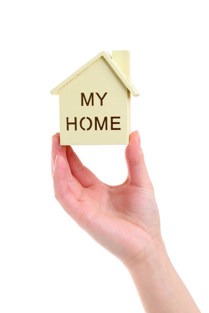 istock Hand holding miniature model of house 644194652