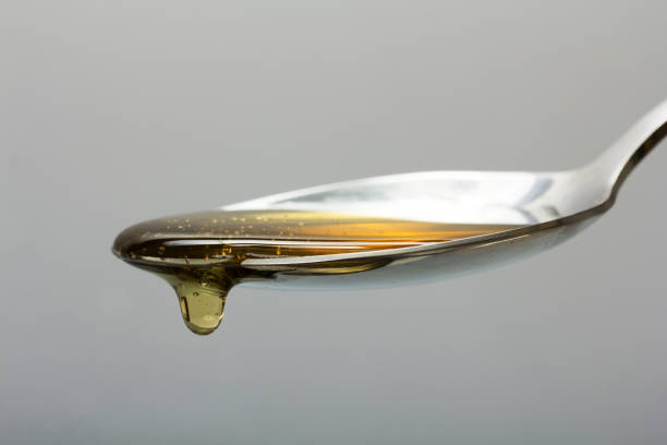 istock Honey pouring from spoon against a light background 644198082