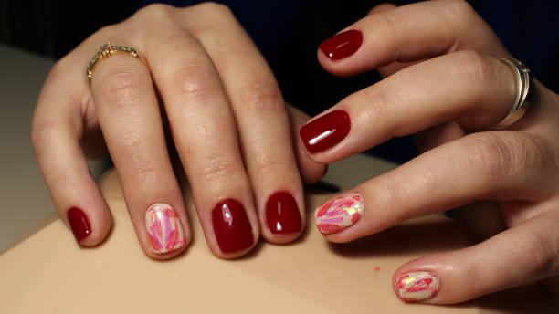 istock Red manicure, sweet feathers on broken glass 644216822