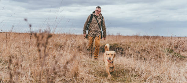 istock Hiker and dog in grassland 644218264
