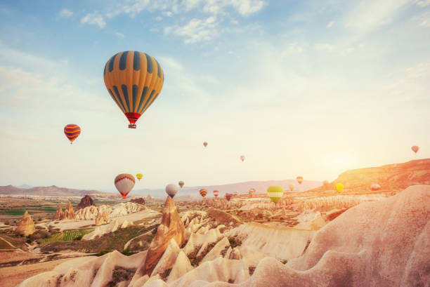 hot air balloon flying over rock landscape at turkey. cappadocia - inflating balloon blowing air imagens e fotografias de stock