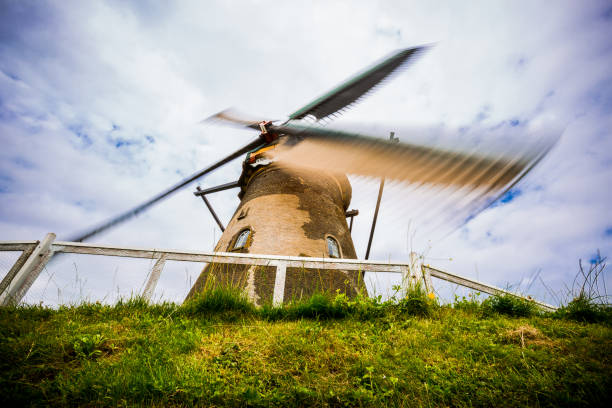 Old moving windmill taken from below with cloudy skies in Holland in Kinderdijk