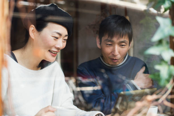 istock Mature adult couple using digital tablet at cafe 644228470