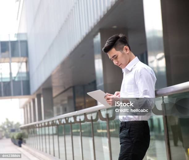 Young Asian Businessman Using Tablet At Office Exterior Stock Photo - Download Image Now