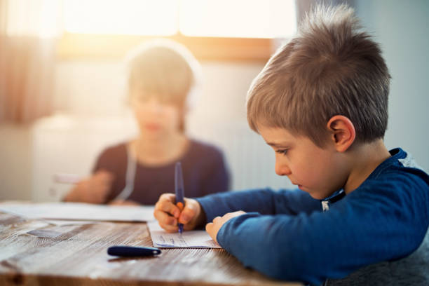 petit garçon et sa sœur aînée, faire leurs devoirs - fountain pen flash photos et images de collection