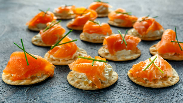 istock Smoked Salmon and soft chees canapes appetizers with chives on stone table 644244666