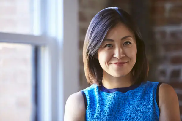 Photo of Portrait Of Businesswoman In Office Standing By Window