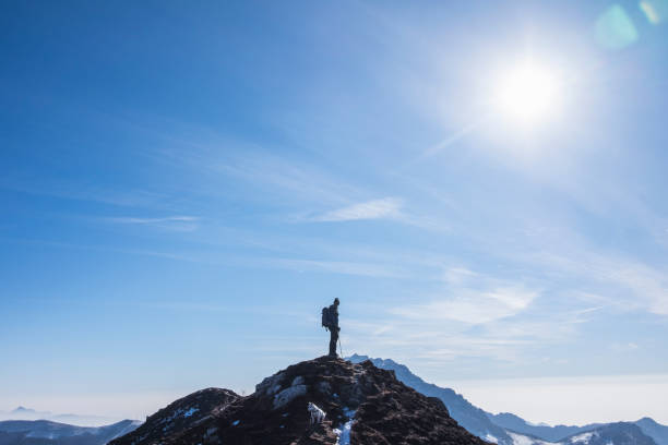 istock Hiker standing on edge of mountain looking away 644249588