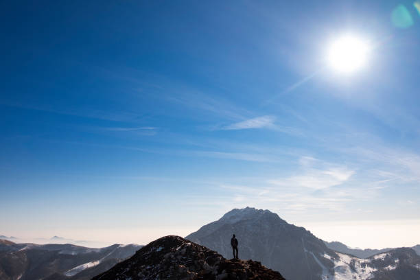 istock Hiker standing on edge of mountain looking away 644249590