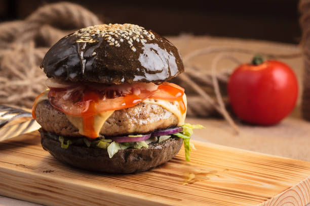 istock Trendy glossy burger with beef in black bun 644263582