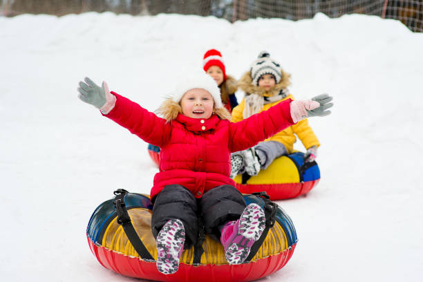istock Kids on snow tubes downhill at winter day 644276508