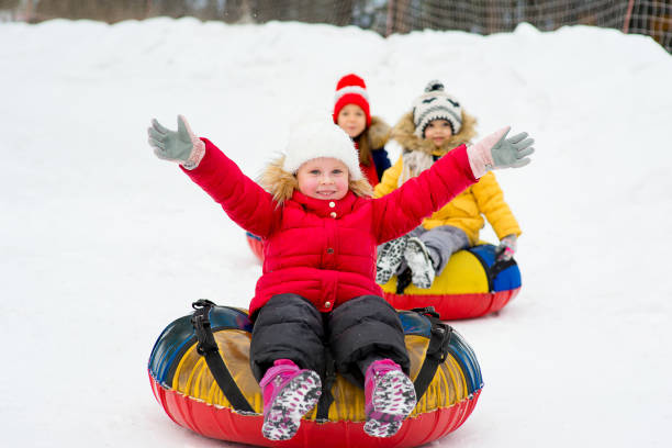 istock Kids on snow tubes downhill at winter day 644276538