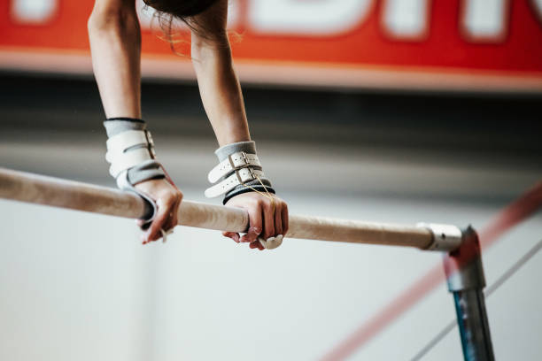 istock hands young girl gymnast exercise on uneven bars 644276640
