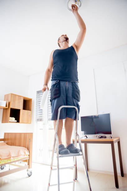 istock Electrician Changing Light Bulb In The Elderly Center 644282484