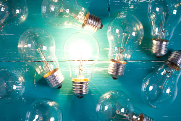 istock Vintage incandescent bulbs on turquoise wooden table 644283734