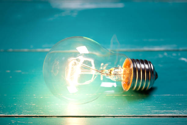 istock Vintage incandescent bulb on turquoise wooden table 644284302