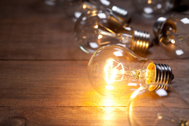 istock Vintage incandescent bulb on old wooden table 644285732
