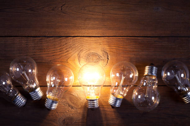 istock Vintage incandescent bulbs on old wooden table 644286672